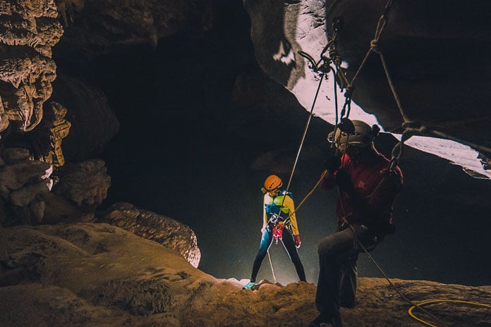 Experience 15m underground abseil using ropes and harnesses in Tu Lan Cave