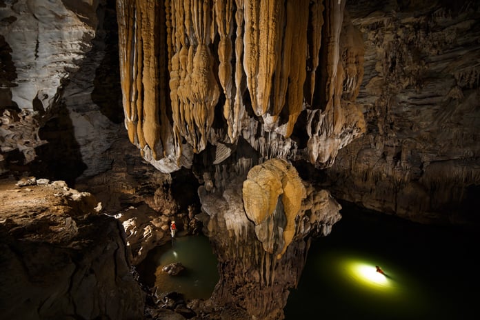 Explore the underground river in Kim Cave.