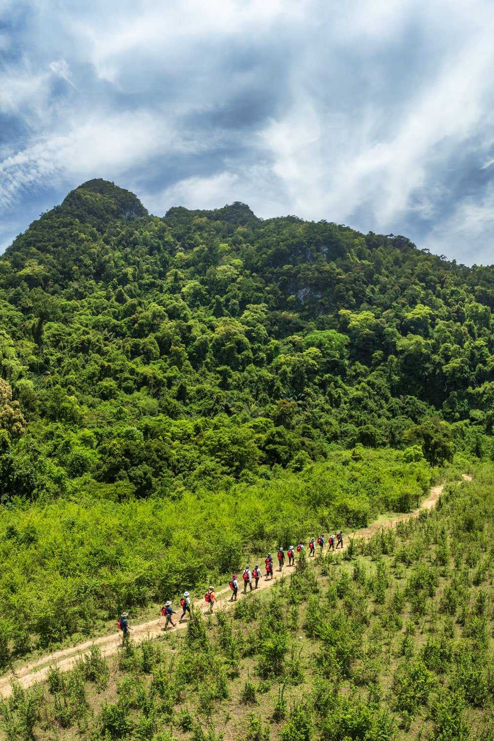 The trekking trail winds through a lush green valley.